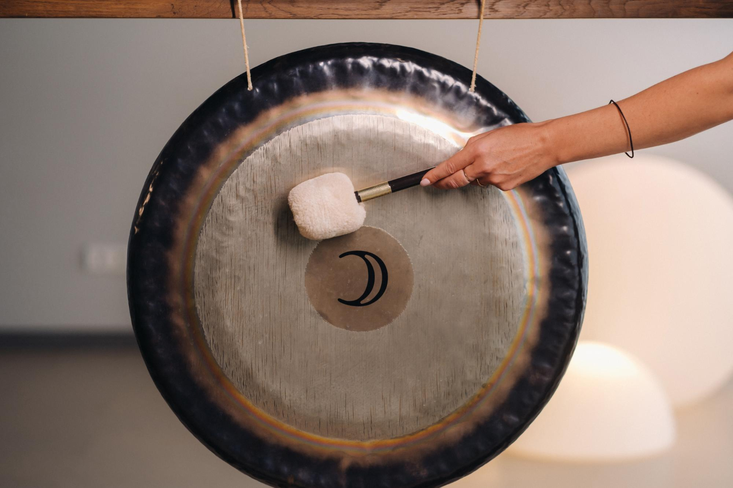 closeup-woman-s-hand-pounding-gong-with-hammer-gong-hand-beater-gong closeup-woman-s-hand-pounding-gong-with-hammer-gong-hand-beater-gong